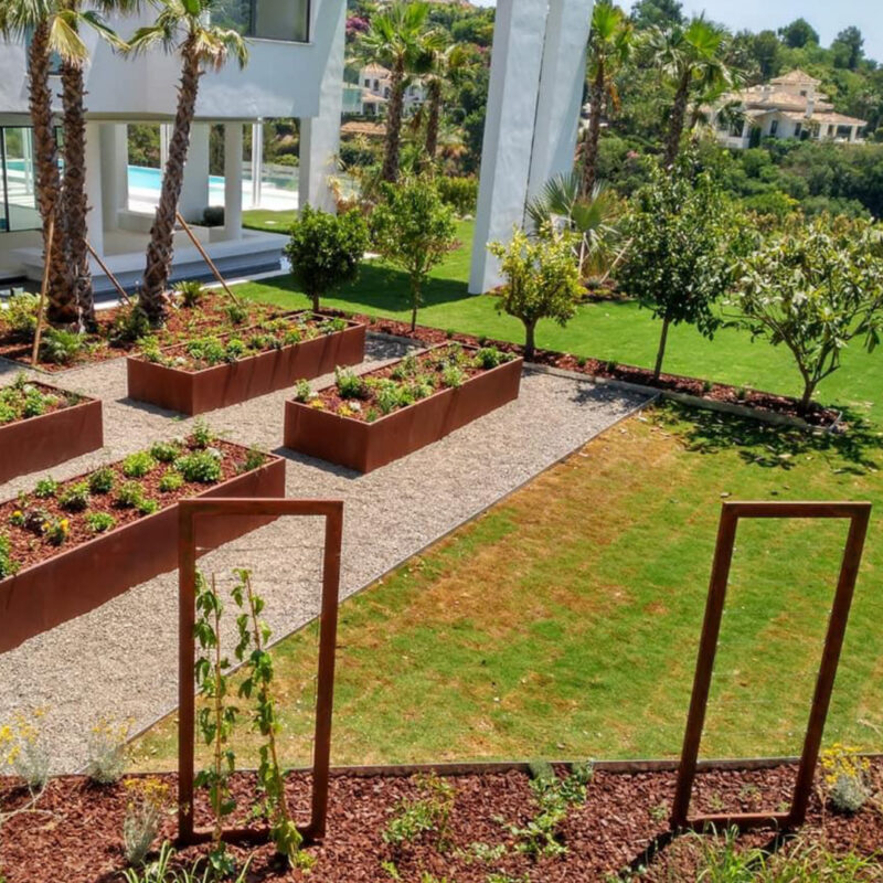Jardineras y estructuras decorativas de acero corten, que aportan un estilo elegante y duradero al paisaje exterior de una vivienda.
