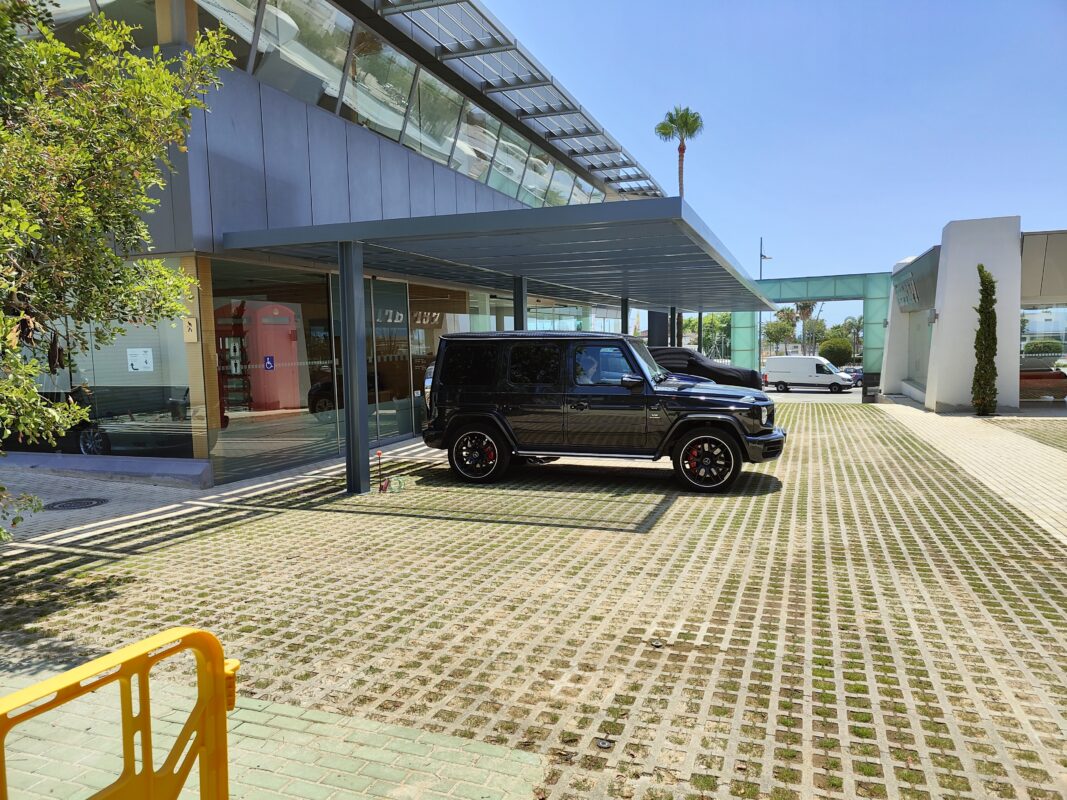 Marquesinas metálicas para coches instaladas en un aparcamiento exterior de diseño contemporáneo.