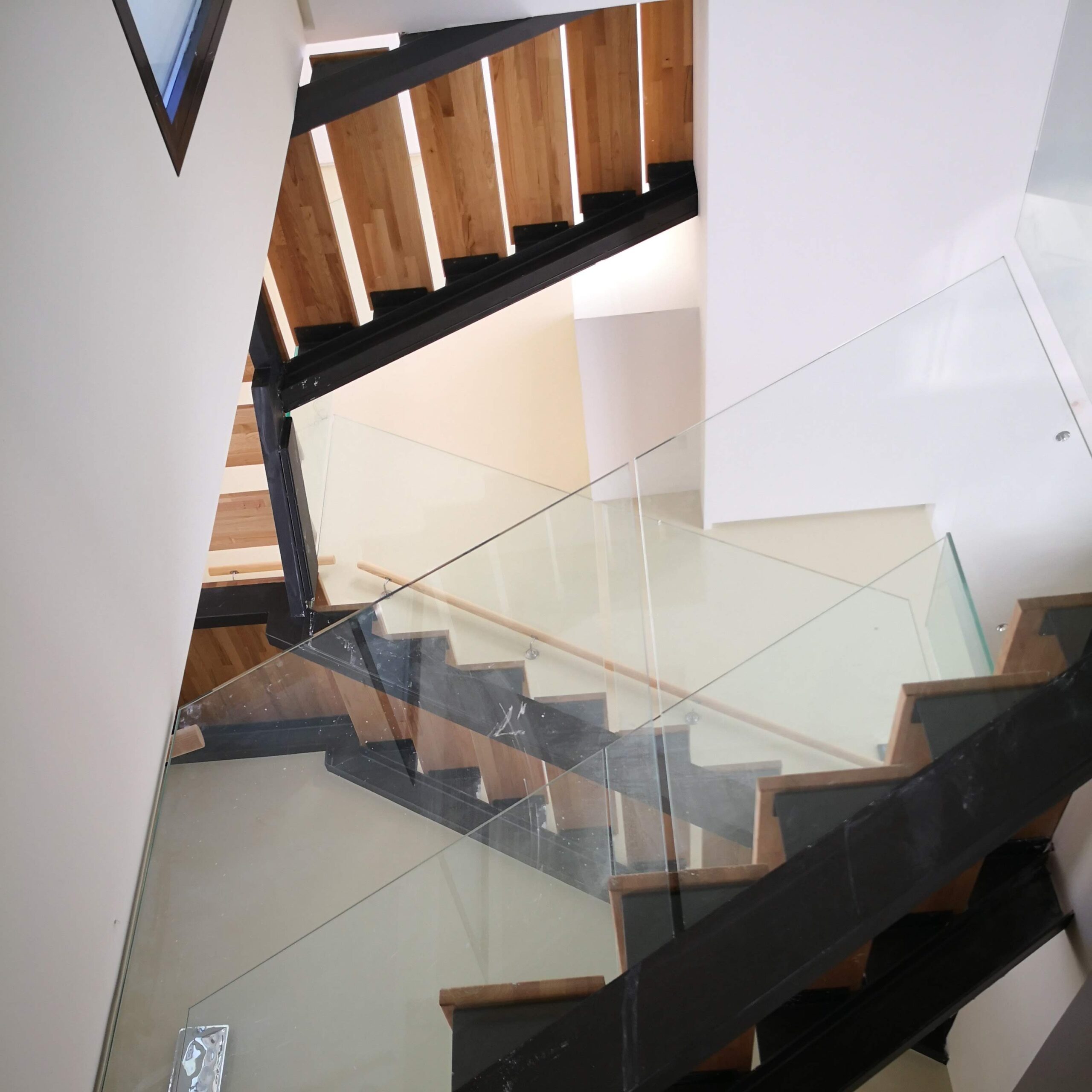 Escalera interior de diseño contemporáneo fabricada con estructura de carpintería metálica, una combinación elegante que aporta luminosidad al espacio.